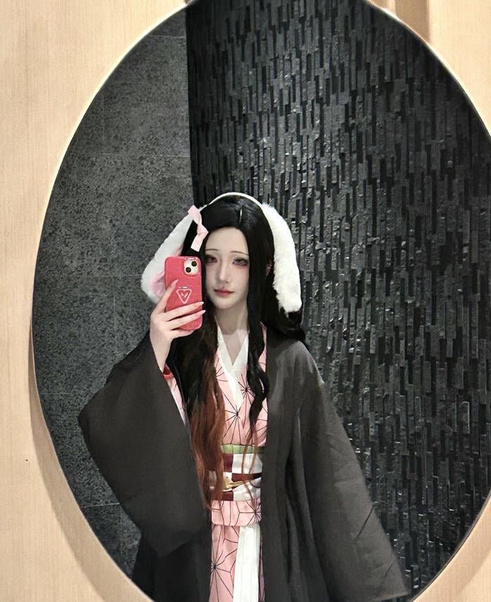 Cosplay Nezuko anime đứng dưới hoa anh đào rực rỡ