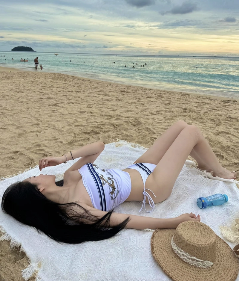 Hình ảnh gái xinh mặc bikini đi biển che mặt đang nằm