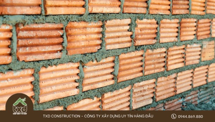 Hình ảnh một viên gạch nung đỏ truyền thống đặt trên bề mặt, thể hiện sự cứng cáp và sẵn sàng cho công trình xây dựng.
