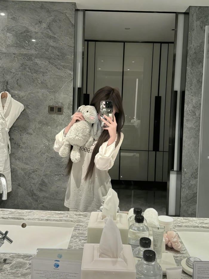 hình gái che mặt bằng điện thoại trước gương dọc