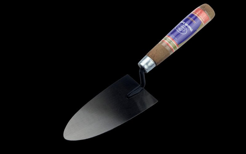 Một chiếc bay thợ hồ tiêu chuẩn với cán gỗ và lưỡi thép sáng bóng, dụng cụ không thể thiếu của cái bay xây nhà